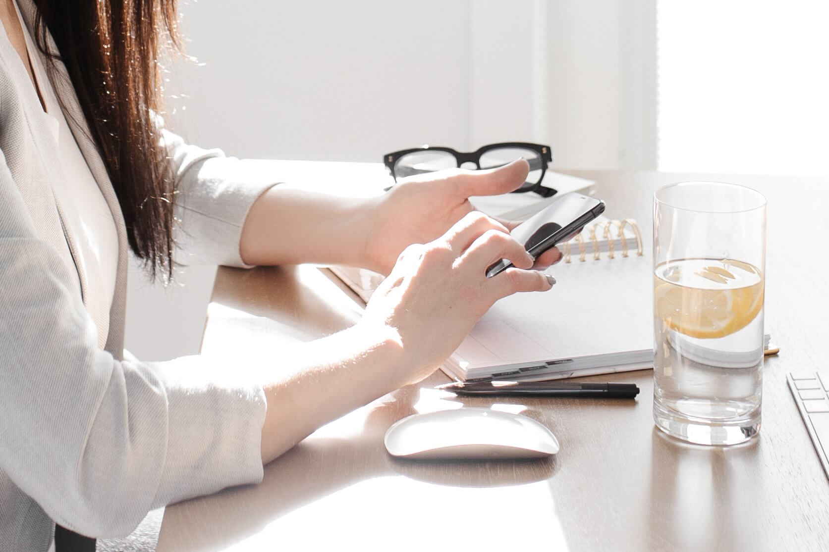 Person typing on phone at desk